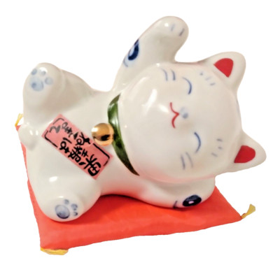 A beckoning cat who believes in the proverb the good news is to sleep and wait