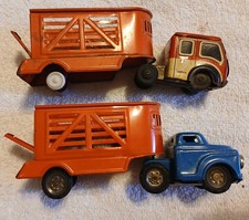 two friction type tin trucks with trailers