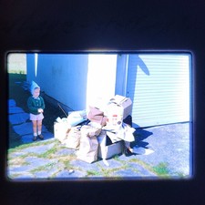 1960s NORWAY, Snapshot photo of Little Girl Next To A Pile Of Trash