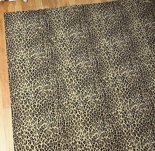 Brown leopard print cotton full flat sheet with black spots, laid flat on a wooden floor.