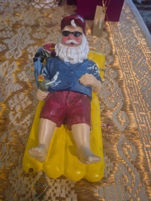 The Poly resin figure  santa relaxing on a float