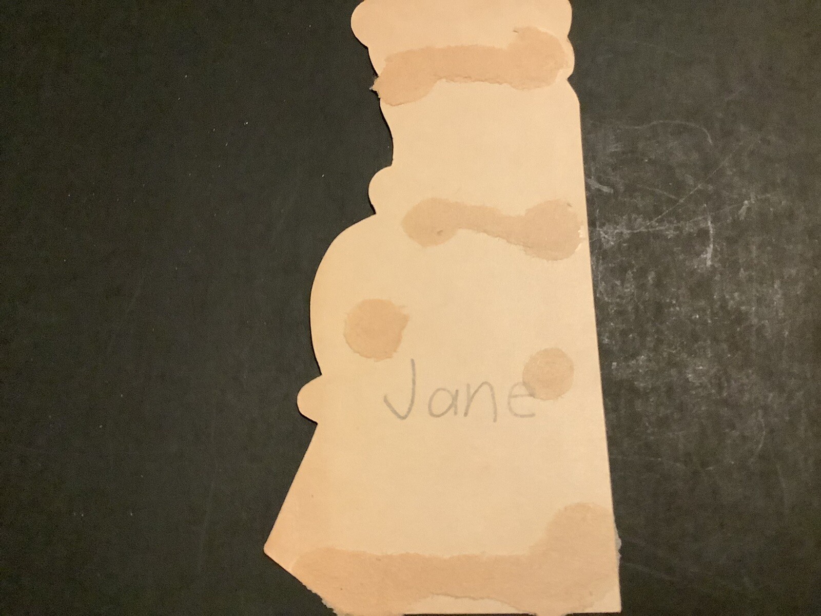 Vintage Valentine card with tan engine block, black “Jane” text, and brown spot accents on a dark background.