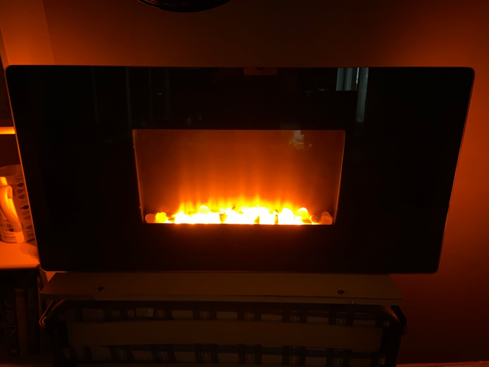 Wallmounted electric fire with flame effect, pebbles and coloured