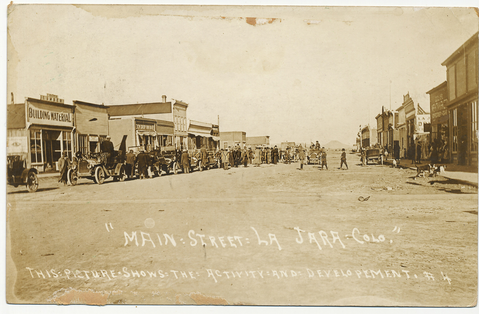 1912 RPPC MAIN ST LA JARA COLORADO DEW DROP BAR STORES BUSY CANC