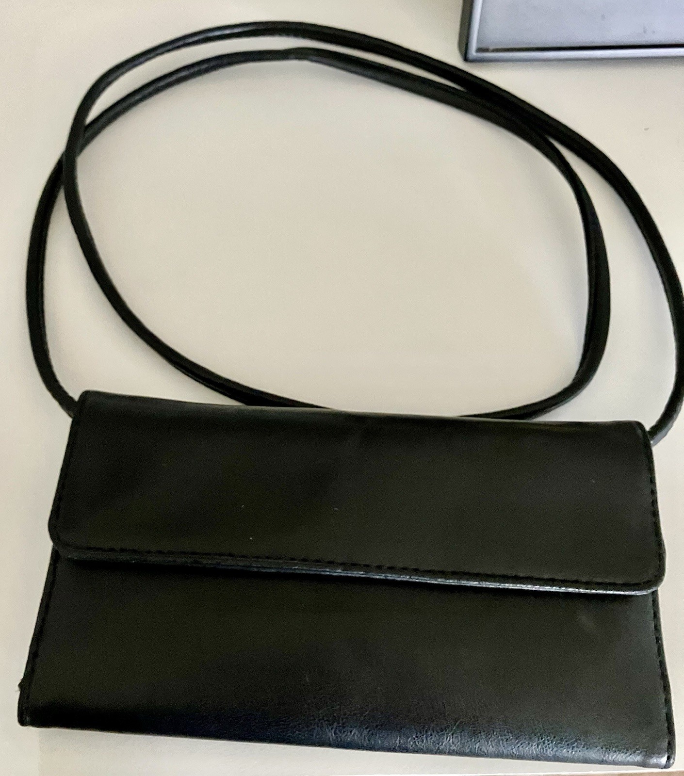 Black faux leather crossbody wallet with a removable strap