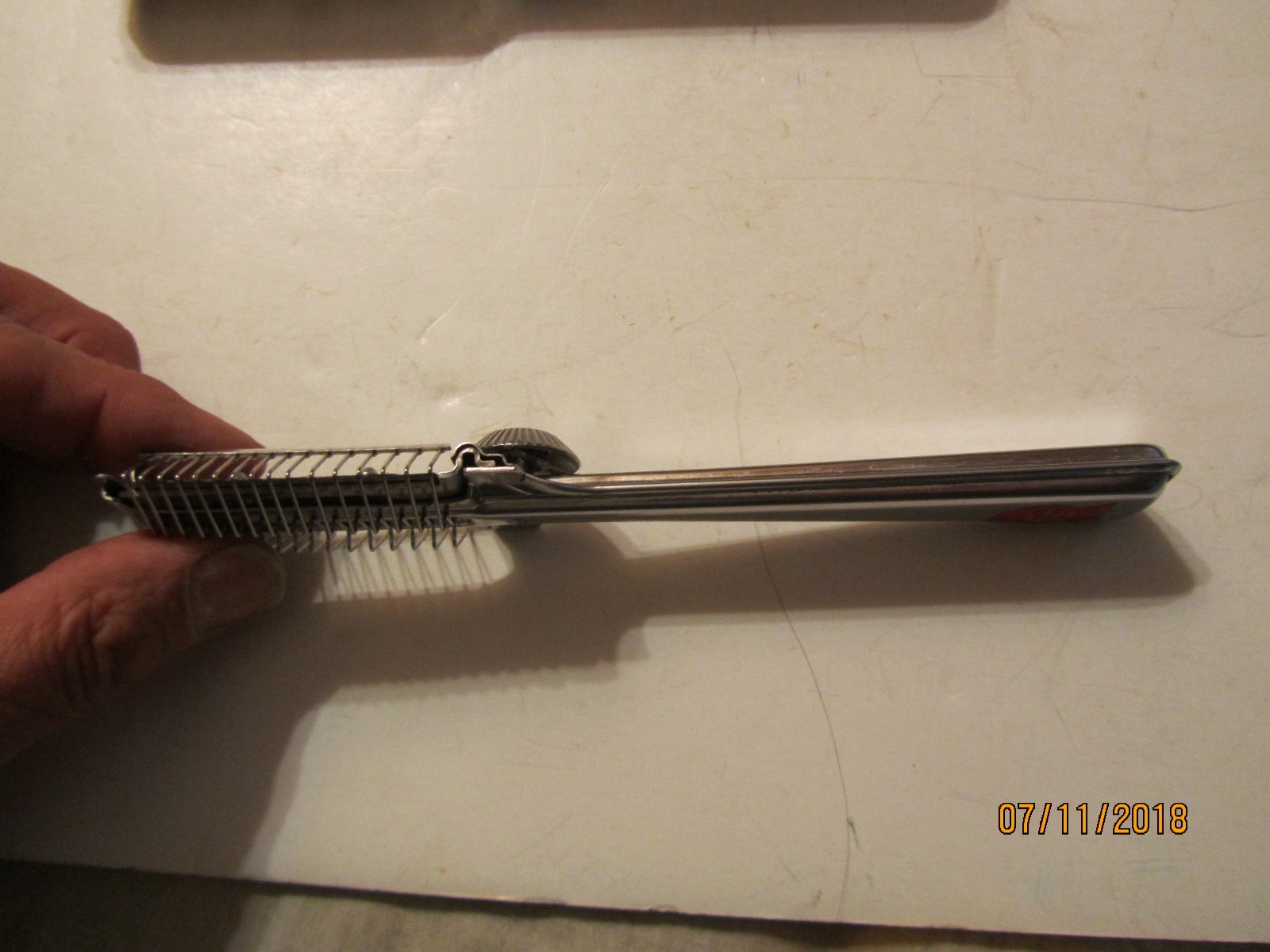 Silver vintage Playtex hair cutter with textured handle and engraved oval case, made in USA on 07/11/2018.