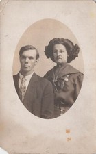 RPPC Young Couple Antique Eyeglasses Fleur de Lis Necklace Photo Postcard E7
