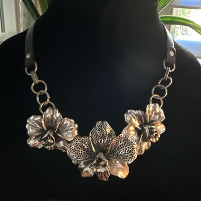 Fossil wild orchard silver tone necklace black leather straps . Is adjustable.