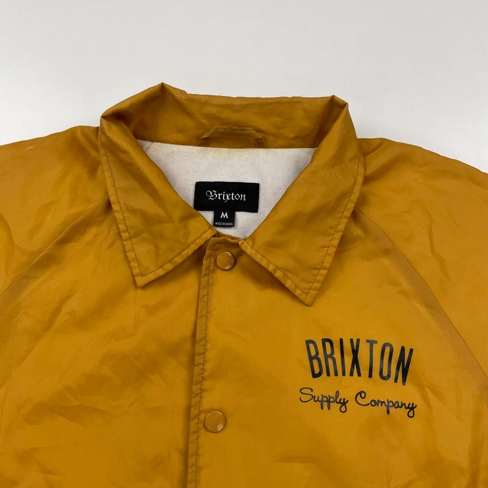 Chaqueta cortavientos Brixton CLYDE Coach para hombre mediana dorada amarilla forrada frontal a presión Foto 3 de 4