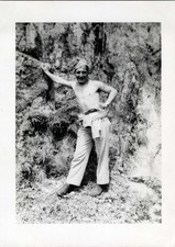 1943 WW2 Photo of Shirtless Soldier Leaning on Rock in Tropical Area
