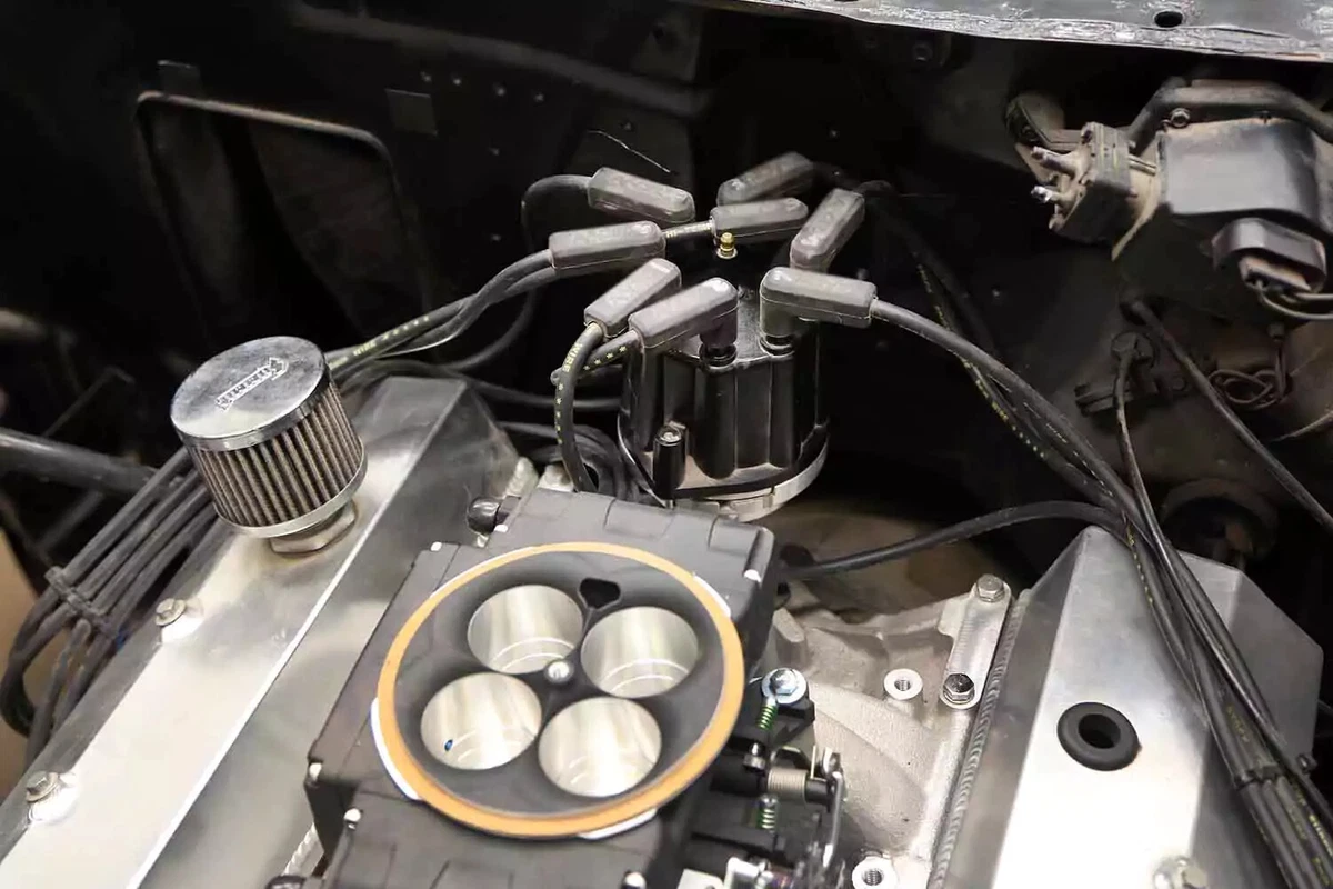 The distributor on this vehicle is located between the firewall and the engine.