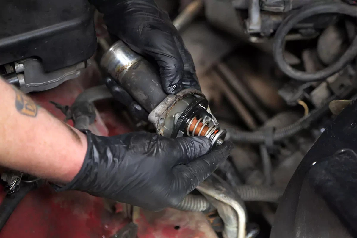 Removing the old thermostat from the water neck.