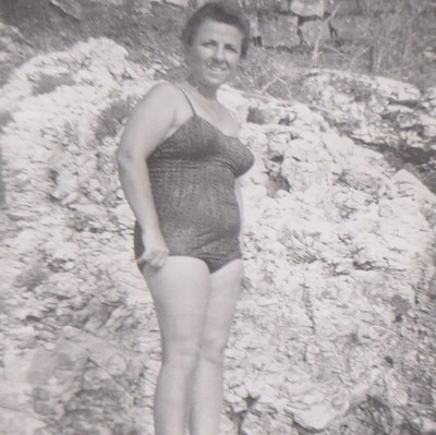 Mature Swimsuit Woman Smiling On Rocky Shore In Sunny Beach Scene Vintage Photo