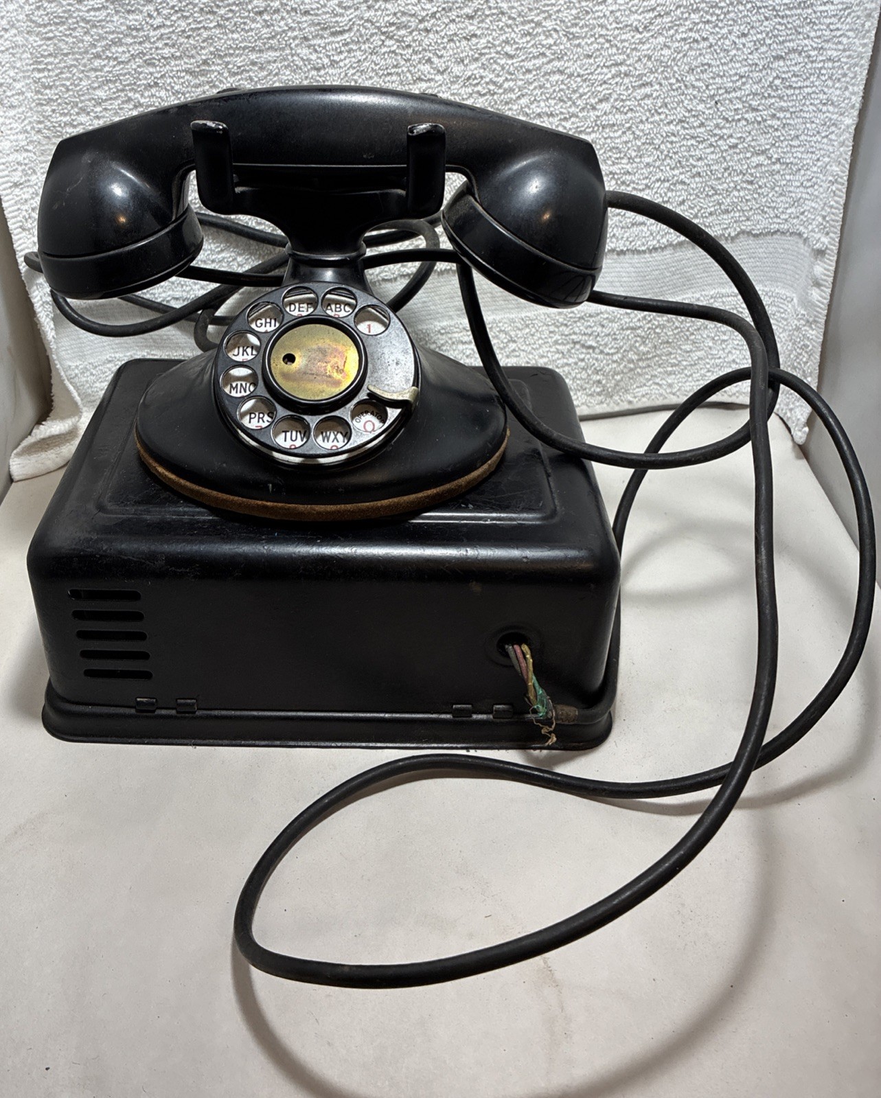 A black Western Electric 202 rotary telephone with its handset, paired with its matching external ringer box.