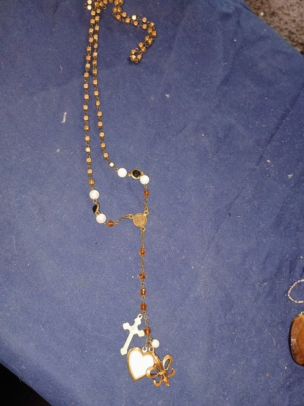 Rosary Necklace With faceted beads, gold-tone metal, and decorative charms.