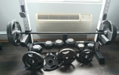 Squat Rack With a barbell and dumbells , weight plates , barbell clamps.