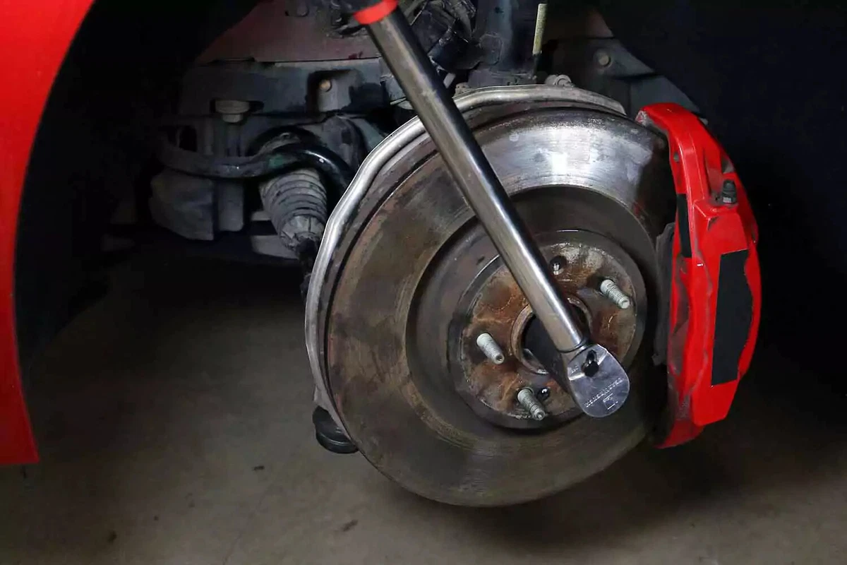 A mechanic uses a torque wrench to tighten the axle nut to factory specifications.