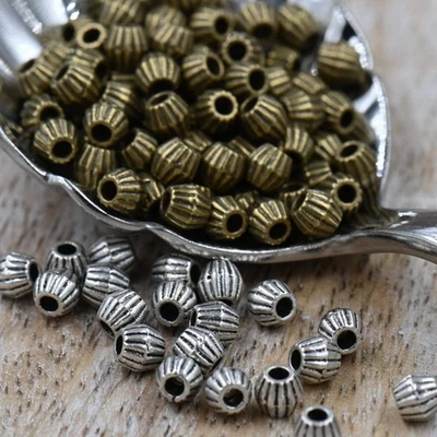 Bronze or Antique Silver, 4mm corrugated bicone. Sold per pkg of 100 - Image 1 of 4