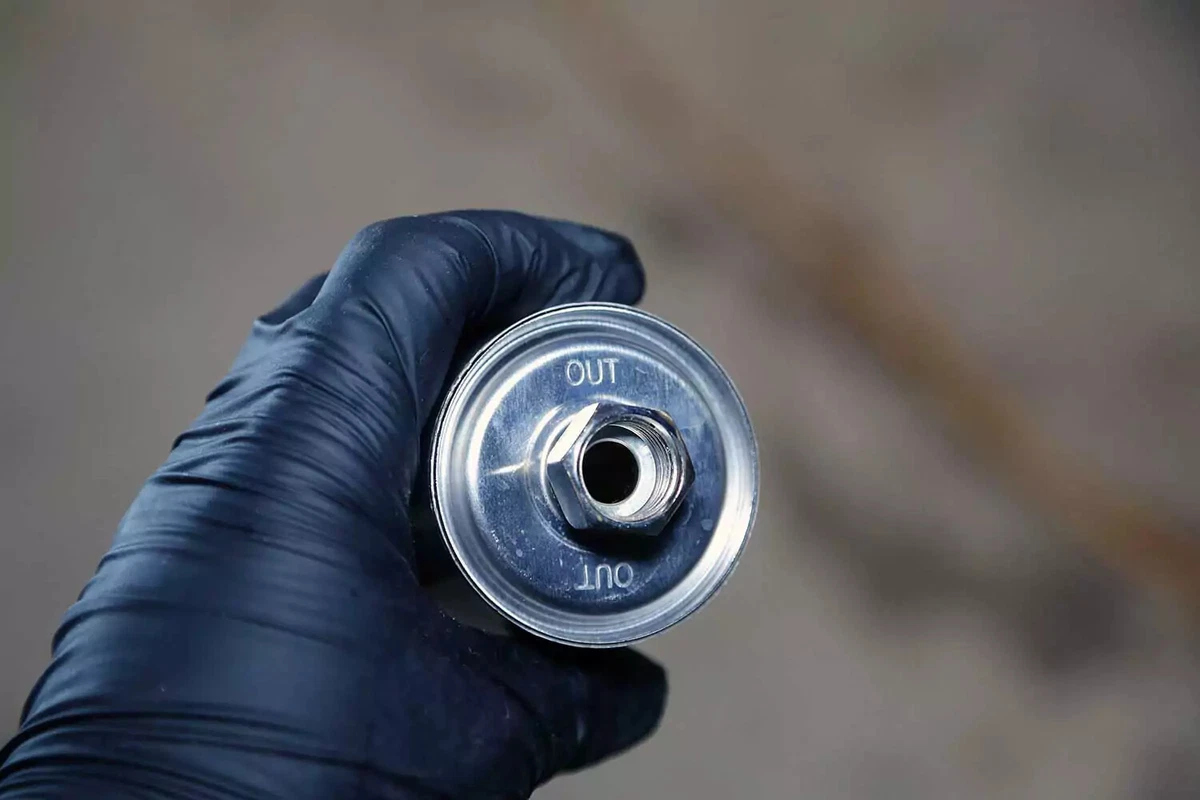 A mechanic checks the fuel filter markings to verify the direction of flow.