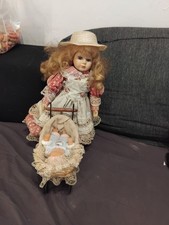 Porzellanpuppe mit Kinderwagen und Babypuppe.