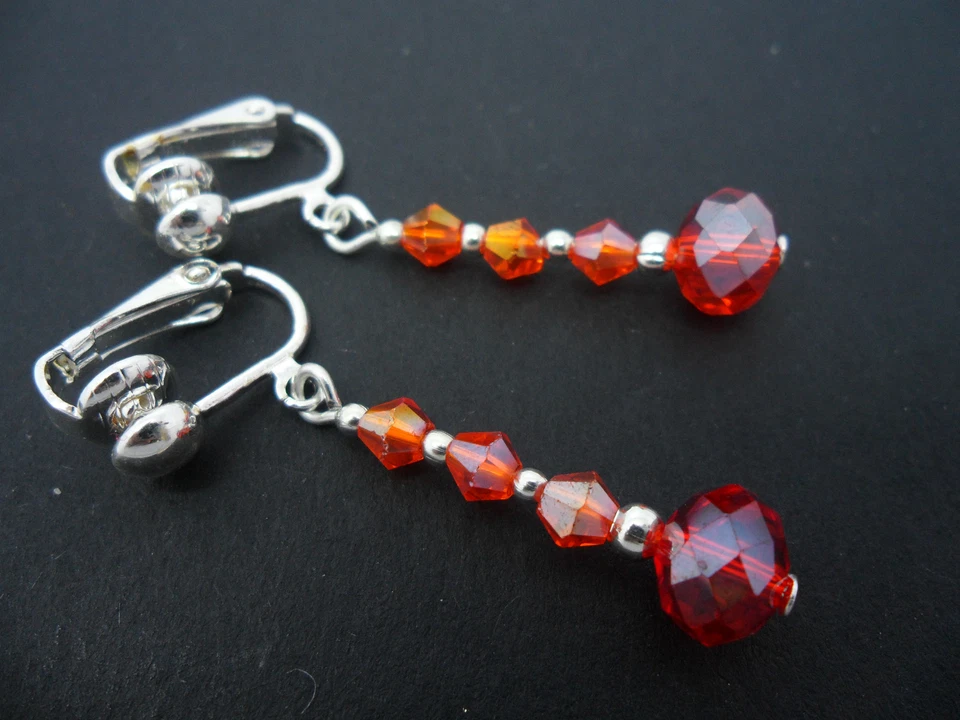 A PAIR OF DANGLY RED CRYSTAL BEAD SILVER PLATED DROP CLIP ON EARRINGS. - Image 1 of 1