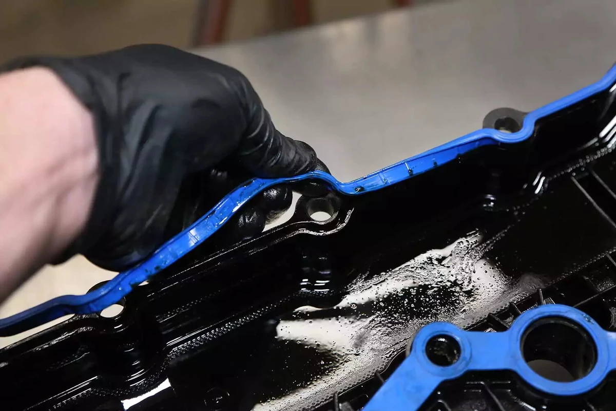 Mechanic carefully installing the new gasket on the valve cover.