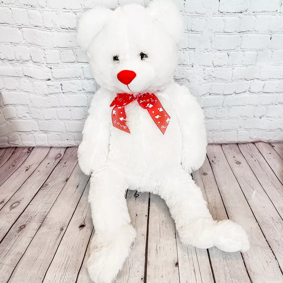 Big white teddy bear with red bow discount