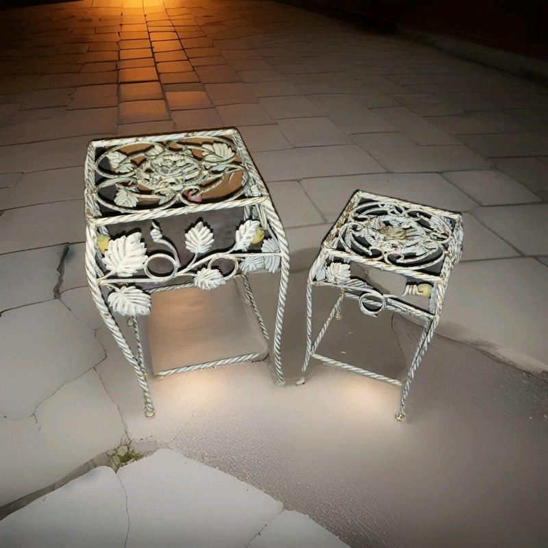2 metal plant stands decorated with fruit and leaf motifs.
