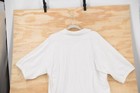 White vintage Harley-Davidson Sturgis 2002 men’s 2XL polo shirt with short sleeves, displayed on a wooden background.