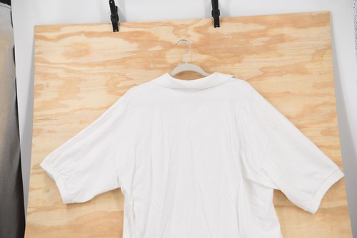 White vintage Harley-Davidson Sturgis 2002 men’s 2XL polo shirt with short sleeves, displayed on a wooden background.