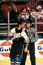 Jim Cummins Mighty Ducks of Anaheim is escorted to the penal- Ice Hockey Photo