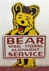 VINTAGE 1955 DATED BEAR WHEEL ALIGNMENT 8” PORCELAIN SIGN GAS OIL SERVICE