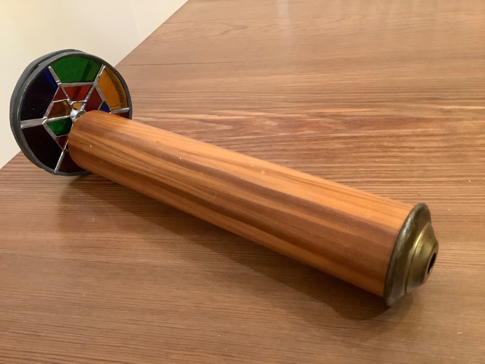 Handmade rotating colored-wheel brass kaleidoscope — the mechanical spinning action makes it a kinetic desk toy, not just a peep-hole novelty.