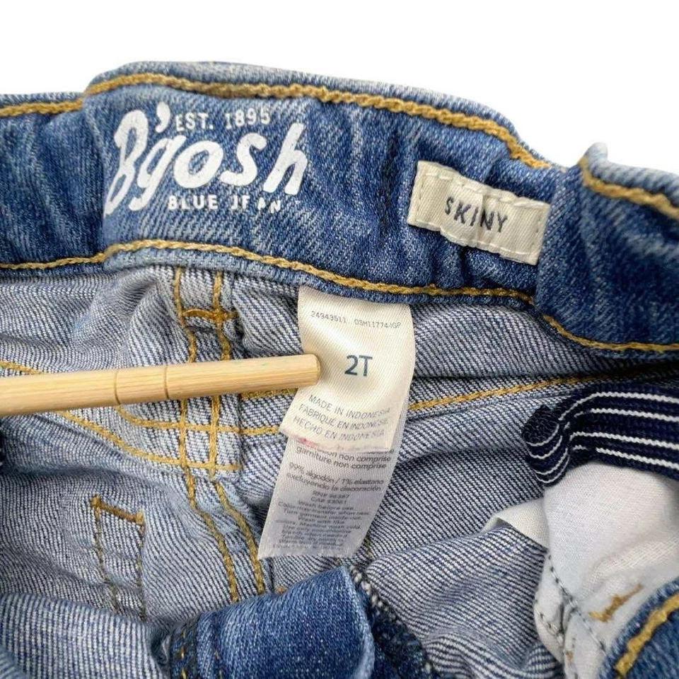 Pantalones de mezclilla rasgados ajustados desgastados OshKosh azules 2T para niños pequeños Foto 3 de 4
