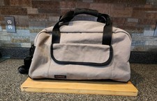 Light grey Timbuktu canvas duffle bag black webbed carry handles front pocket.