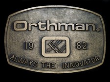 TF09110 NOS VINTAGE 1970s ORTHMAN ALWAYS THE INNOVATOR ADVERTISEMENT BUCKLE