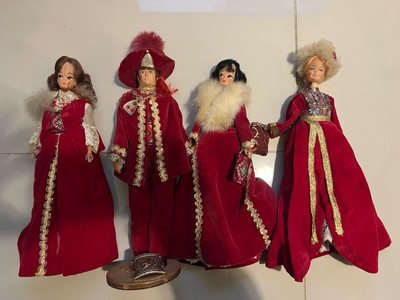 Ein Set aus vier Puppen mit roten passenden Outfits und Hüten