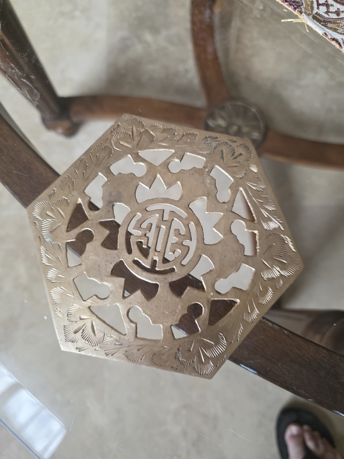 Vintage brass footed trivet with etched floral pattern.