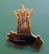 Pin's doré Fairyloot tenant main cage à oiseaux château couronne broche livre