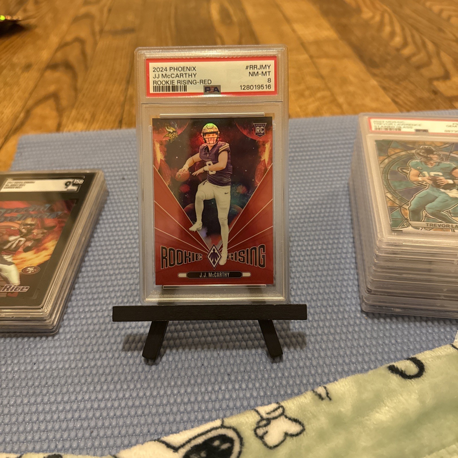 2024 Panini Phoenix - Rookie Rising J.J. McCarthy #RR-JMY Red /99 (RC)