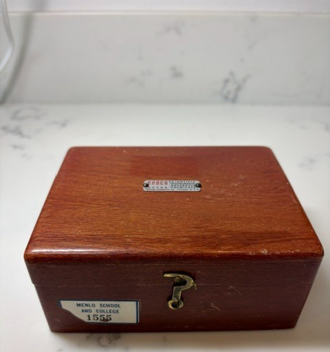 A complete brass calibration weight set in a fitted wood box — looks like something from a Victorian apothecary or a mad scientist's lab.