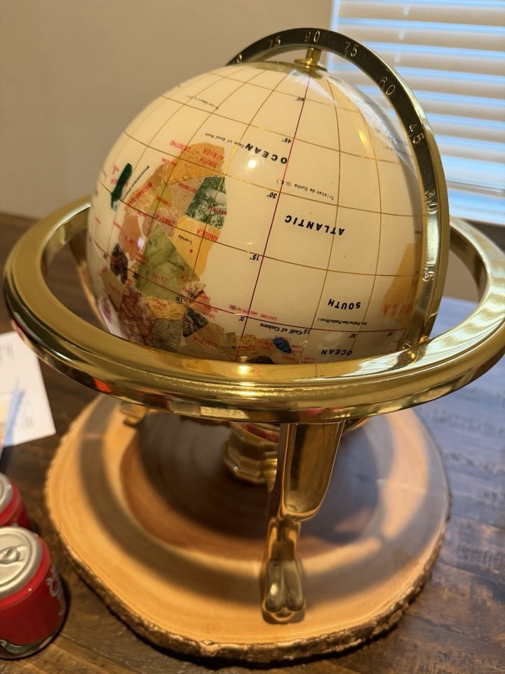A vintage globe with a mother-of-pearl ocean surface and gold finish — the kind of one-of-a-kind desk object that stops every visitor cold.