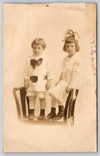 Postcard RPPC Children with Large Bows Siblings in Outfit Real Photo