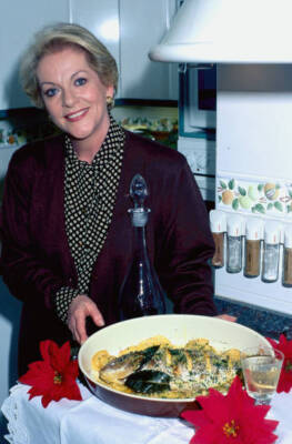 Spanish actress Concha Cuetos with a plate of cooked sea bream, a - Old Photo