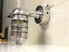 Aplique de pared artesanal de metal pulido con cilindro de vidrio transparente