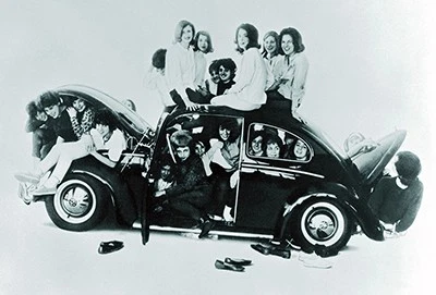 Young people crammed into a Volkswagen Beetle