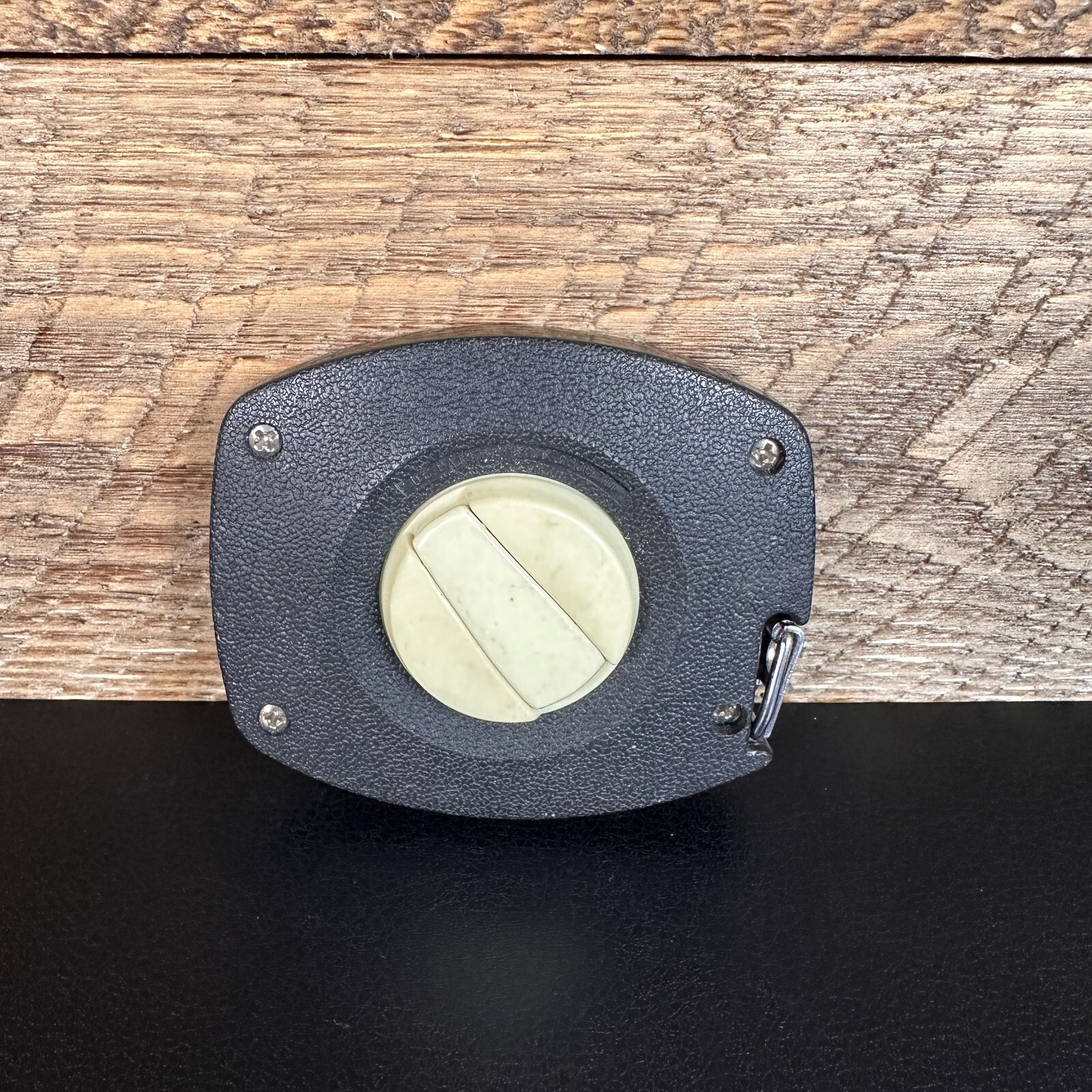 Black textured Stanley 50 foot hand crank with white circular blade and brass screw holes, made in USA.