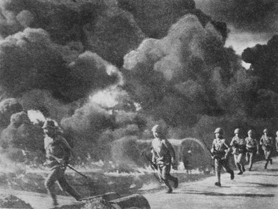 Japanese troops advancing through burning oil fields set alight by- Old Photo