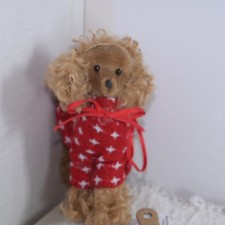 Holiday time brown curly poodle ornament wearing red sweater