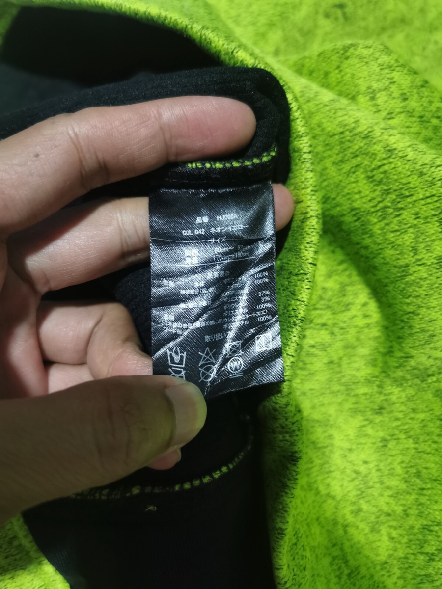 Homme en veste de camouflage vert et noir debout sur le champ d’herbe